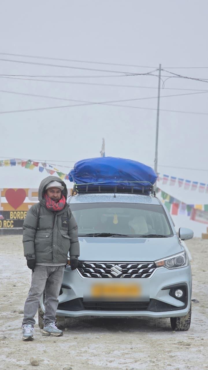 Dorjee Tours Ertiga taxi with local driver at Sela Pass on the Tawang route